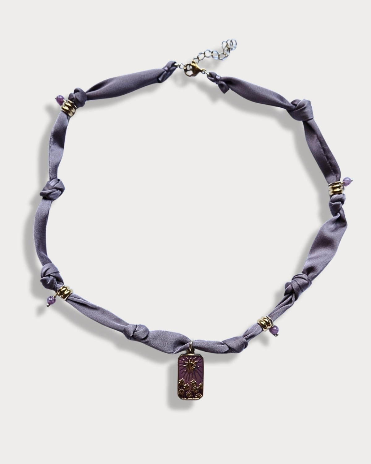 Collana in tessuto annodato color lilla chiaro con pendente con tramonto e pietre di ametista