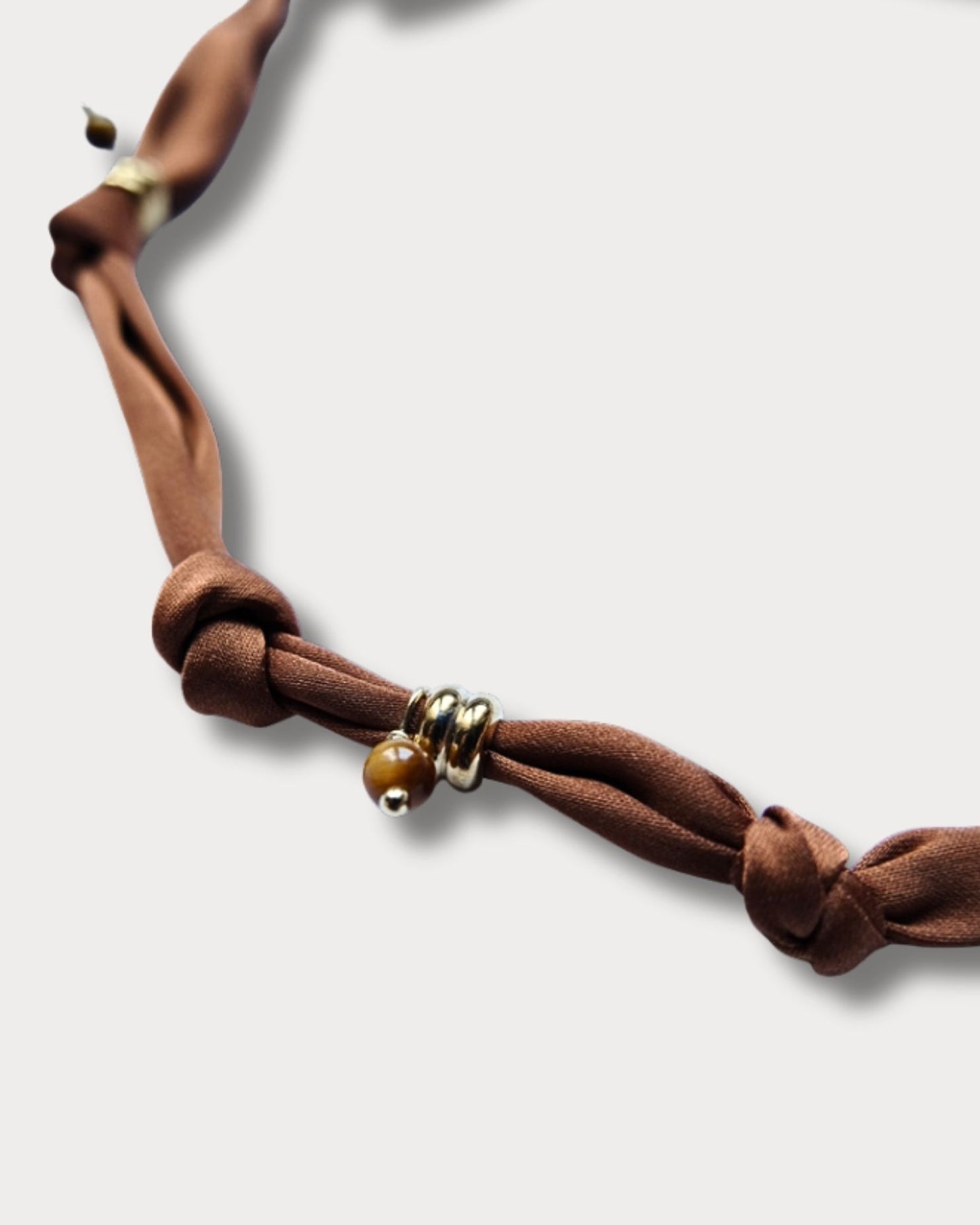 Collana in tessuto annodato marrone bruciato con cuore e pietre di occhio di tigre