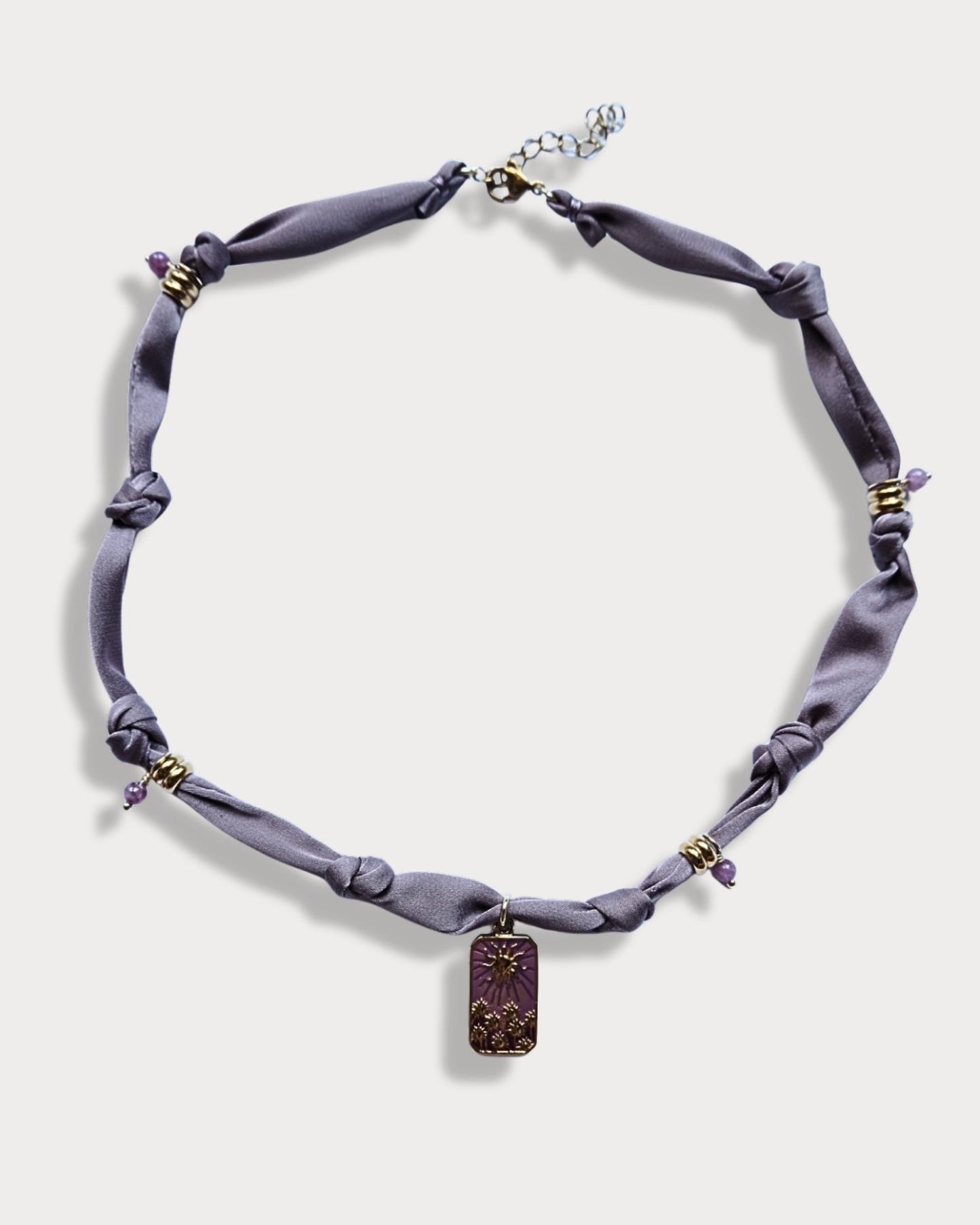 Collana in tessuto annodato color lilla chiaro con pendente con tramonto e pietre di ametista
