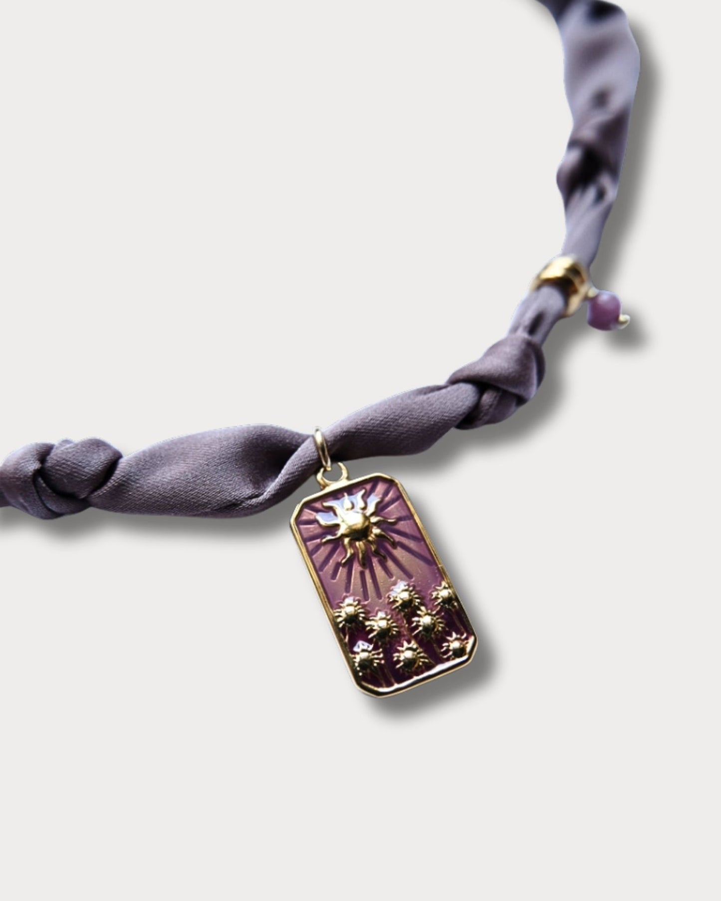 Collana in tessuto annodato color lilla chiaro con pendente con tramonto e pietre di ametista