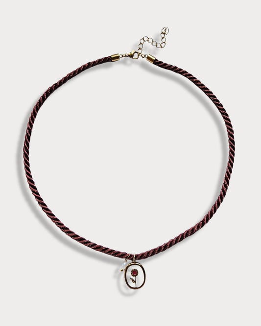 Collana in cordino intrecciato color bordeaux con pendente a forma di fiore e perla di fiume