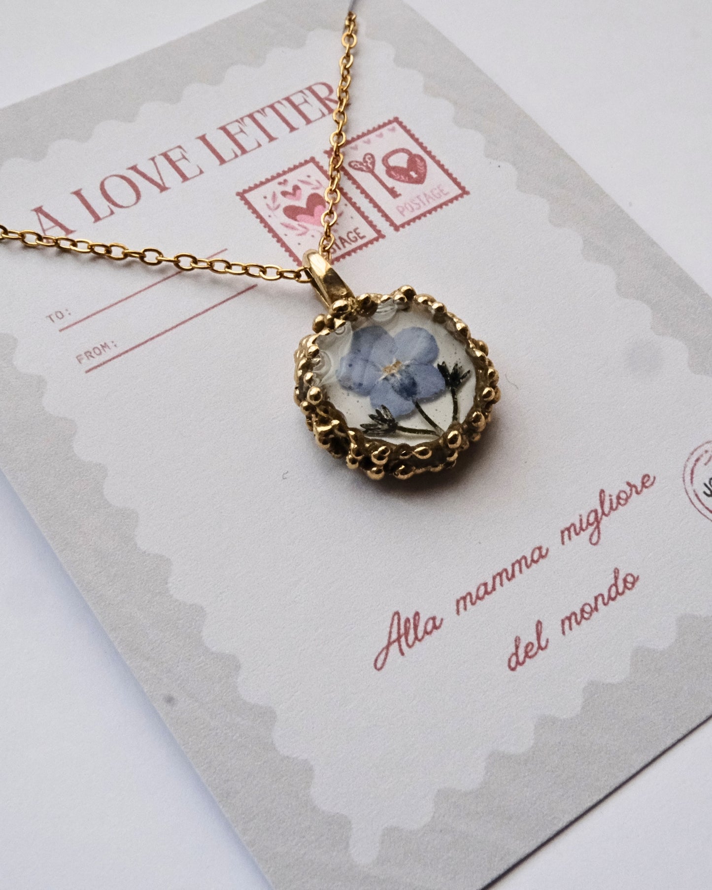 Collana con fiore di non ti scordar di me su base bianca