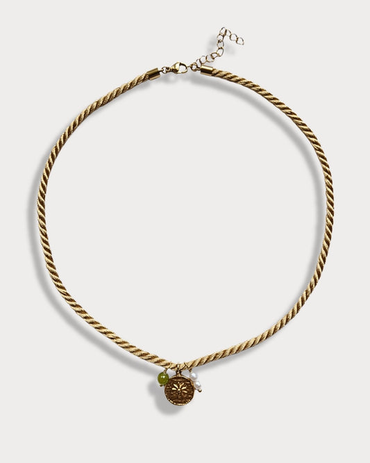 Collana in cordino intrecciato color ocra con pendente a forma di sole e pietra di peridoto e perle di fiume