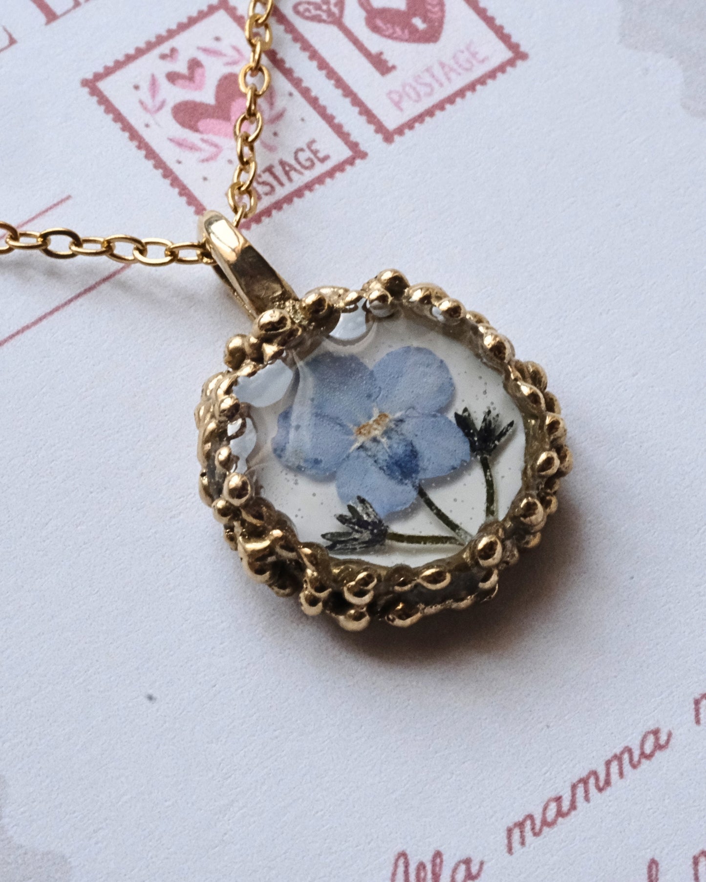 Collana con fiore di non ti scordar di me su base bianca