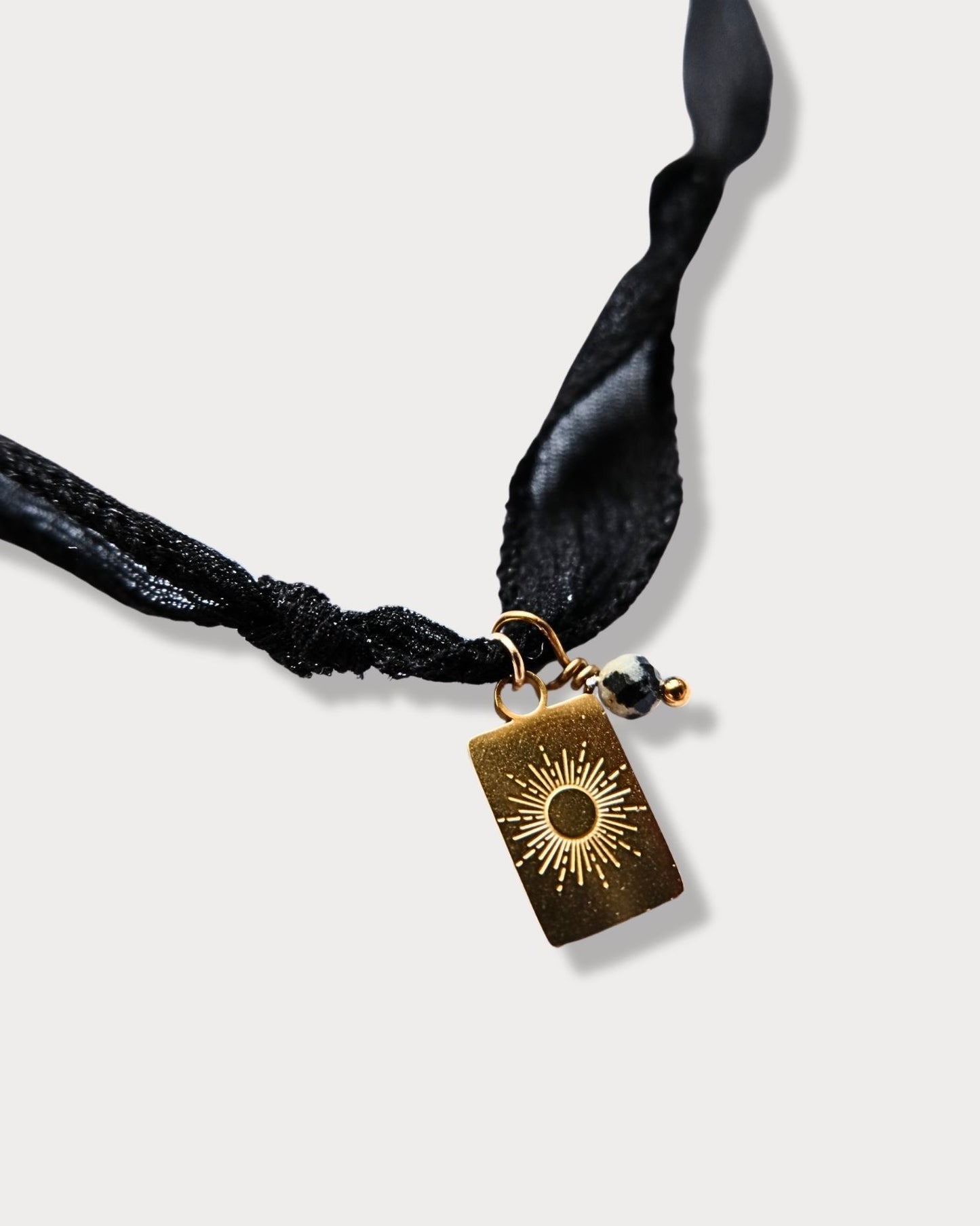 Collana in seta annodata nera con pendente a forma di sole e pietra di diaspro dalmata
