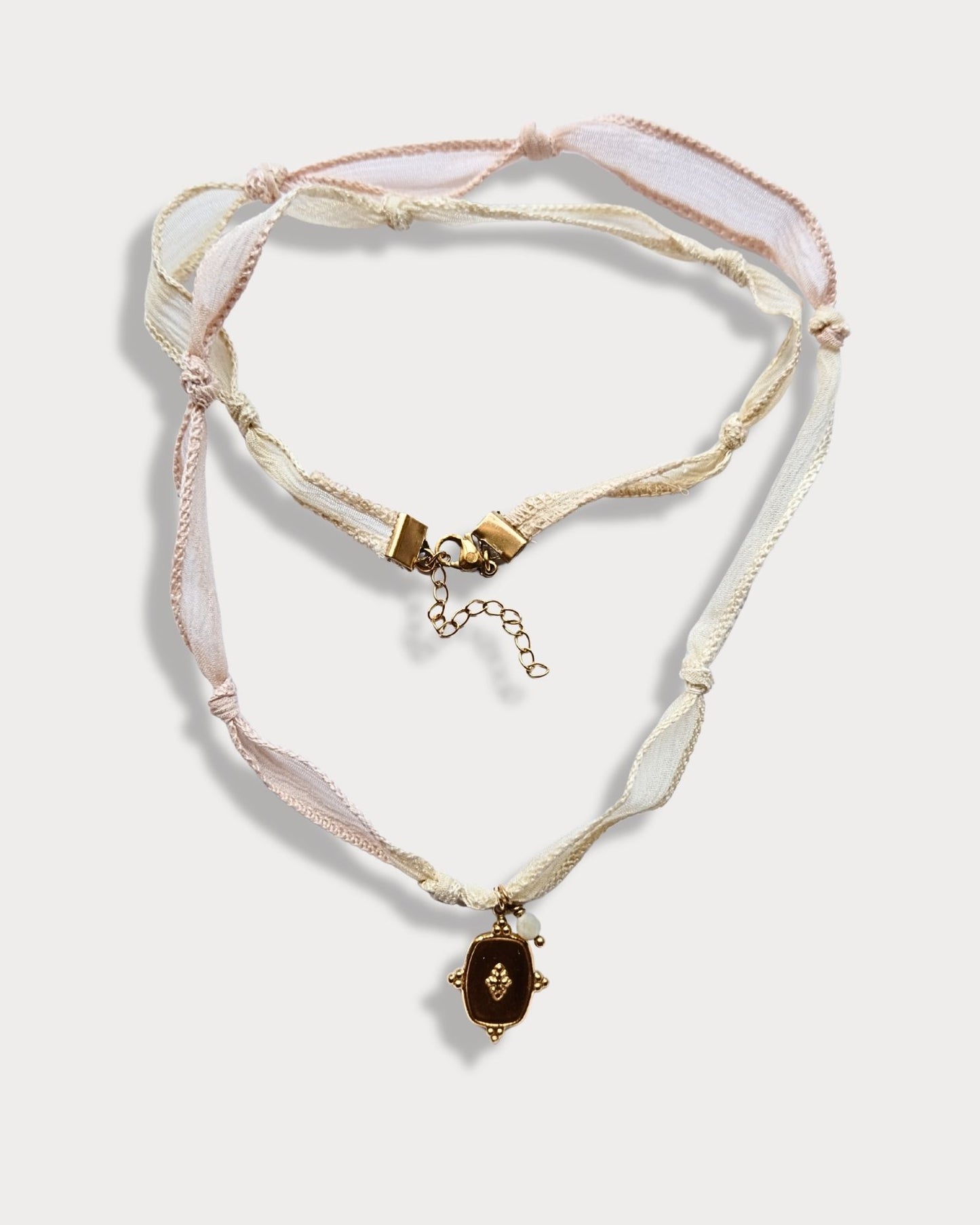 Collana in seta annodata rosa e vaniglia con pendente a forma di medaglietta e pietra di amazzonite