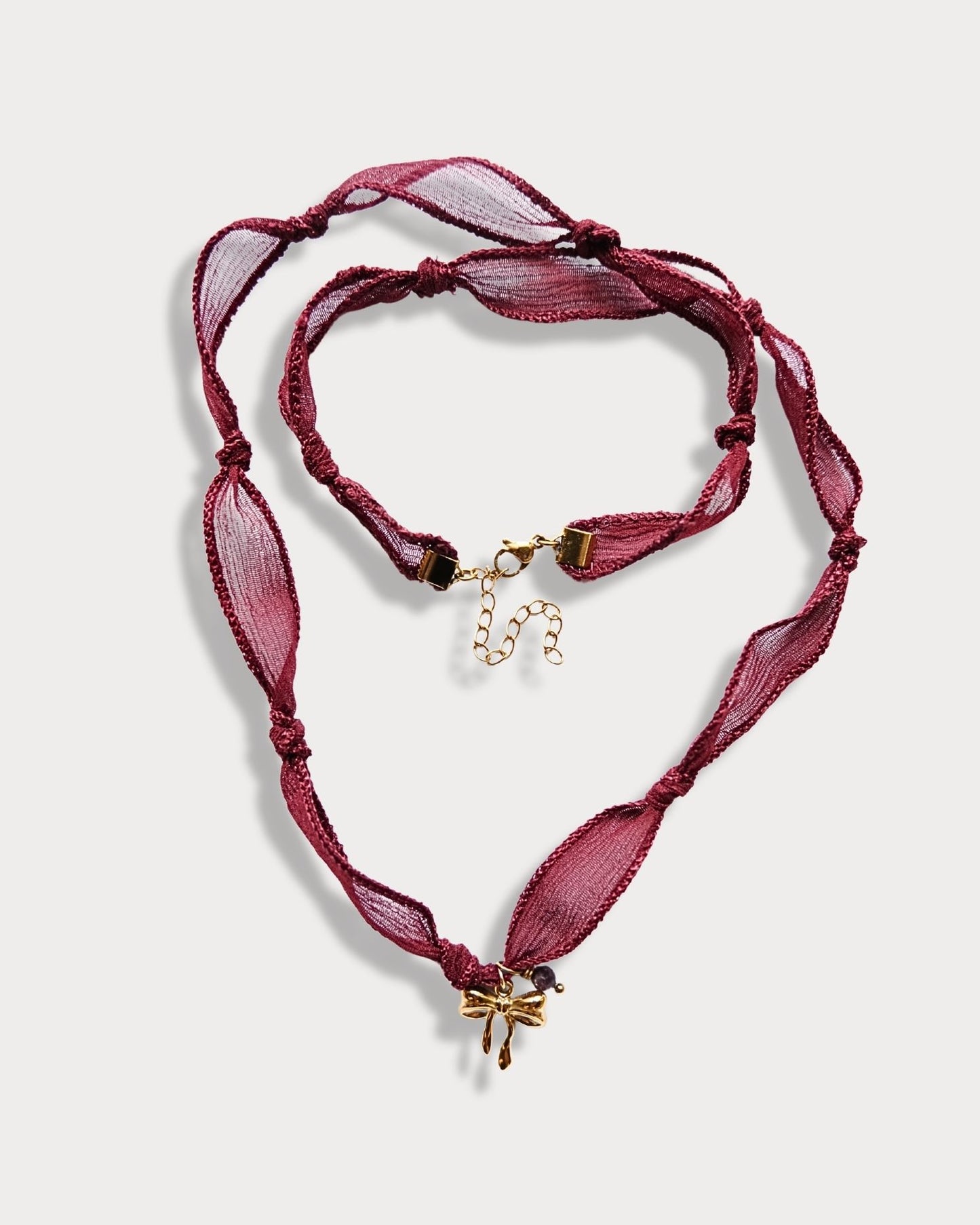 Collana in seta annodata bordeaux con pendente a forma di fiocco e pietra di tormalina