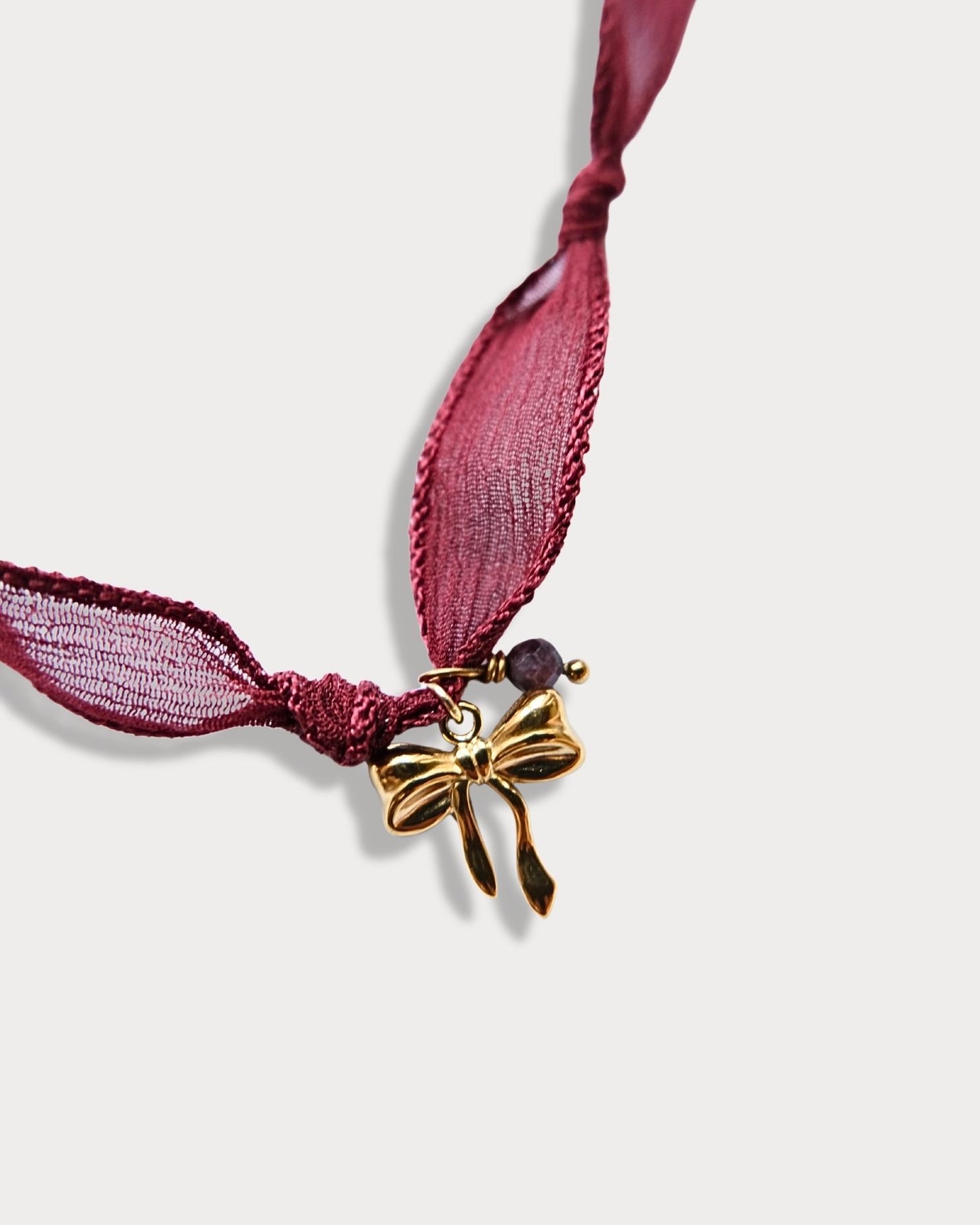 Collana in seta annodata bordeaux con pendente a forma di fiocco e pietra di tormalina