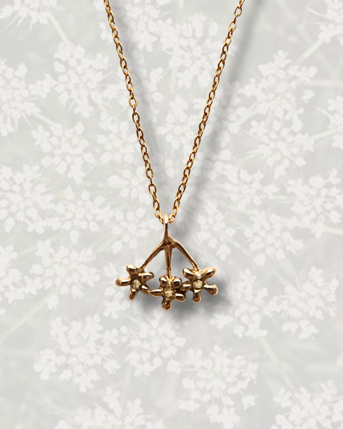 Collana con pendente a forma di carota selvatica in ottone con frammenti di petali