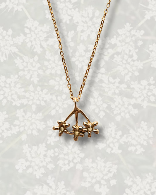 Collana con pendente a forma di carota selvatica in ottone con frammenti di petali