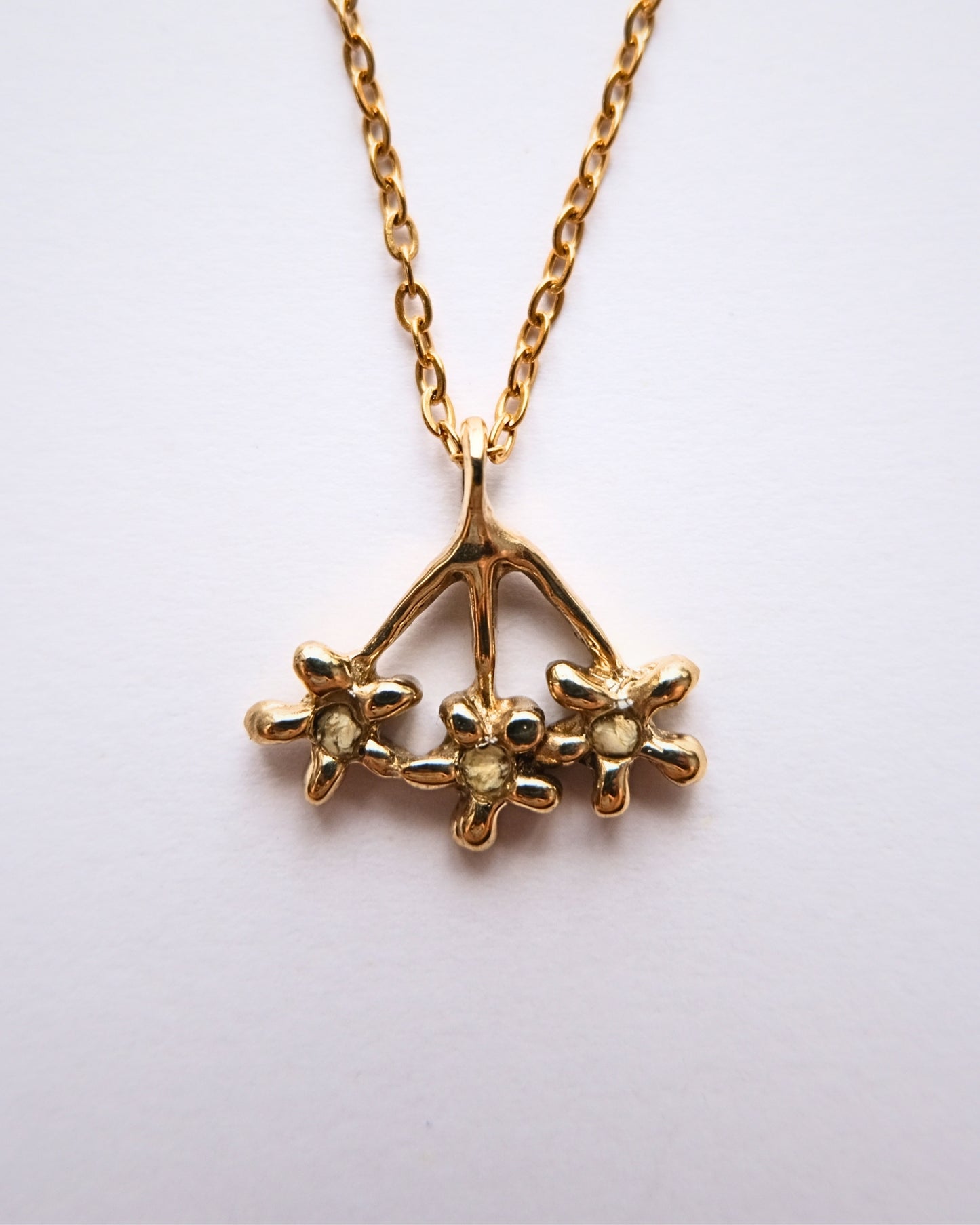 Collana con pendente a forma di carota selvatica in ottone con frammenti di petali
