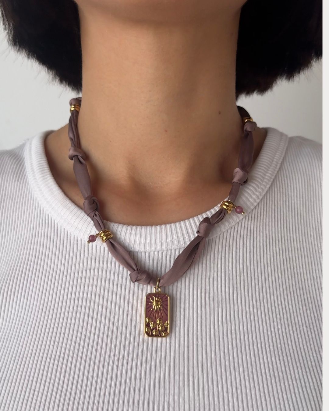 Collana in tessuto annodato color lilla chiaro con pendente con tramonto e pietre di ametista