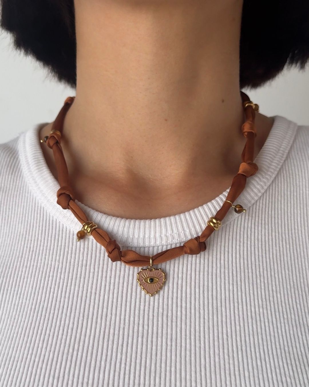 Collana in tessuto annodato marrone bruciato con cuore e pietre di occhio di tigre