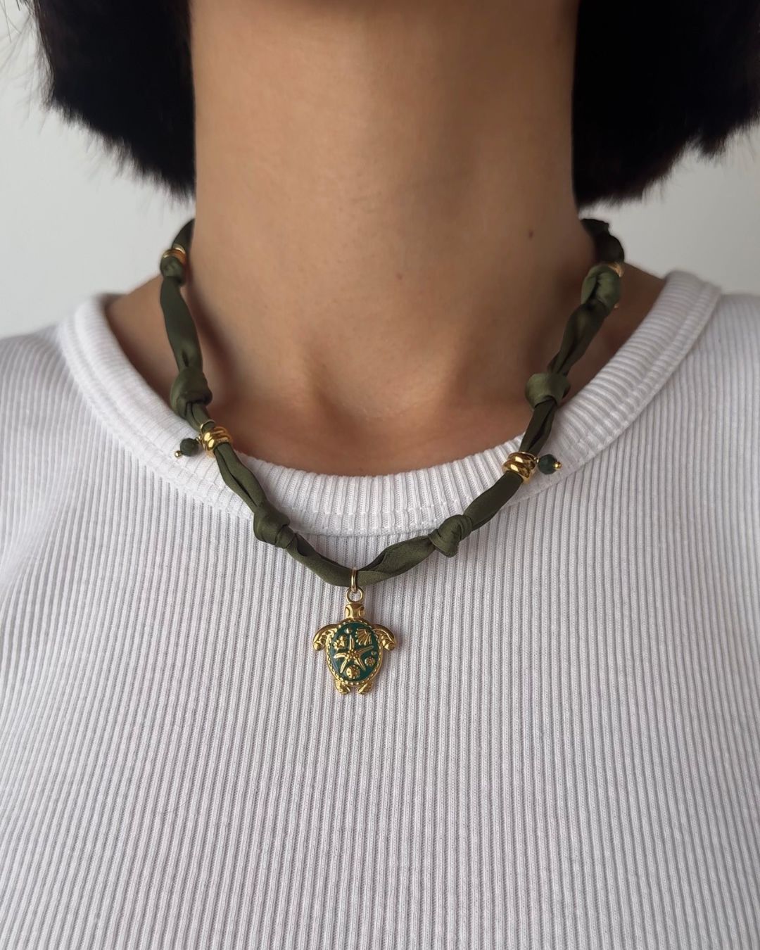 Collana in tessuto annodato verde militare con tartaruga e pietre di agata indiana