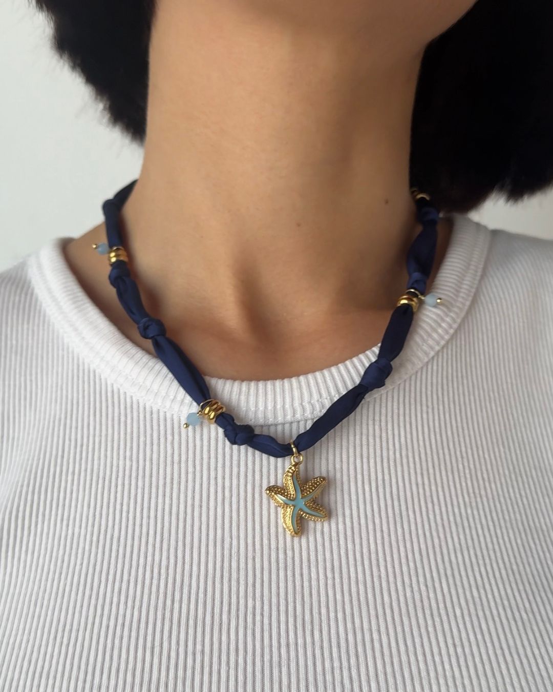 Collana in tessuto annodato blu navy con stella marina e pietre di amazzonite