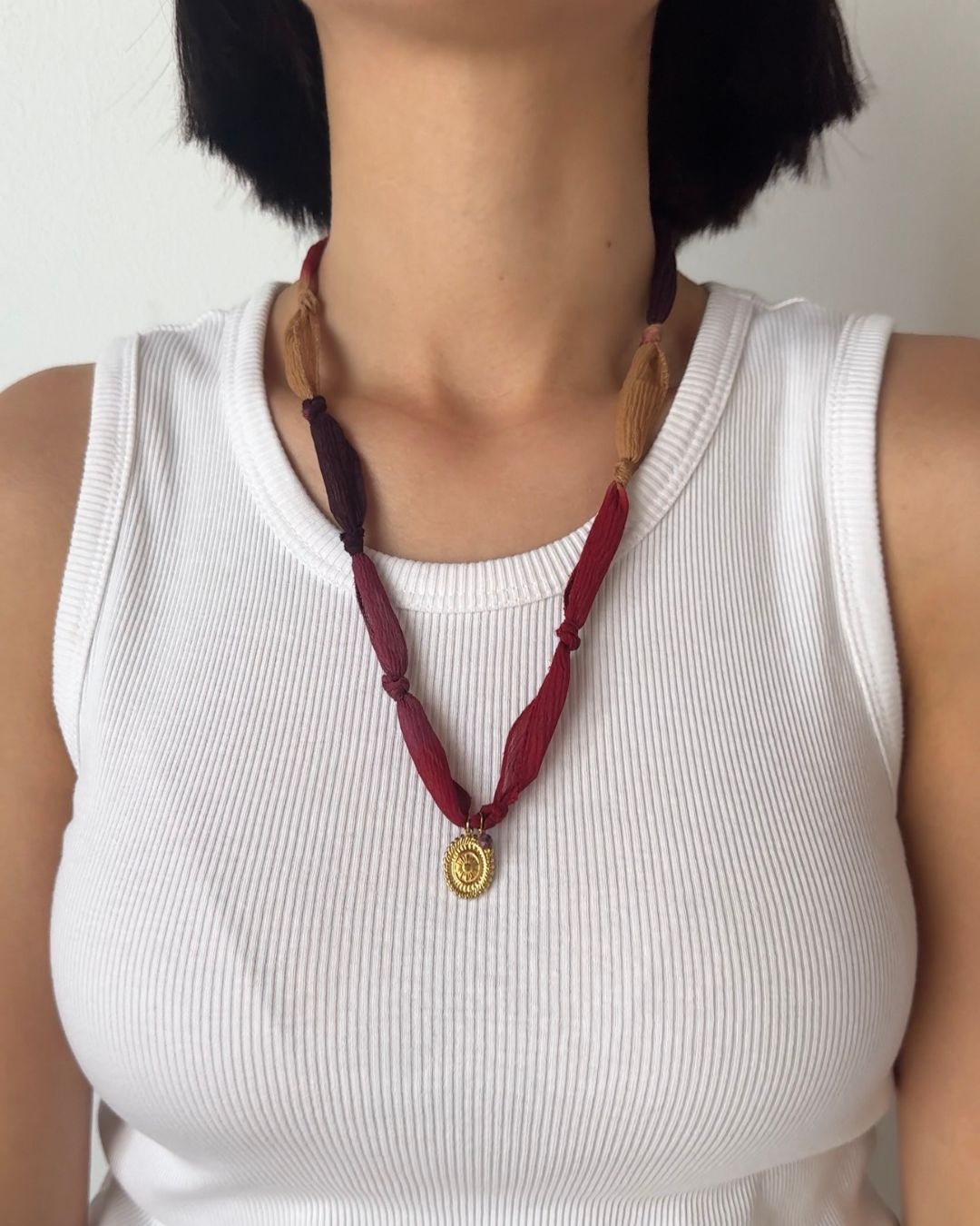 Collana in seta annodata bordeaux, rossa e nocciola con pendente a forma di fiore e pietra di tormalina