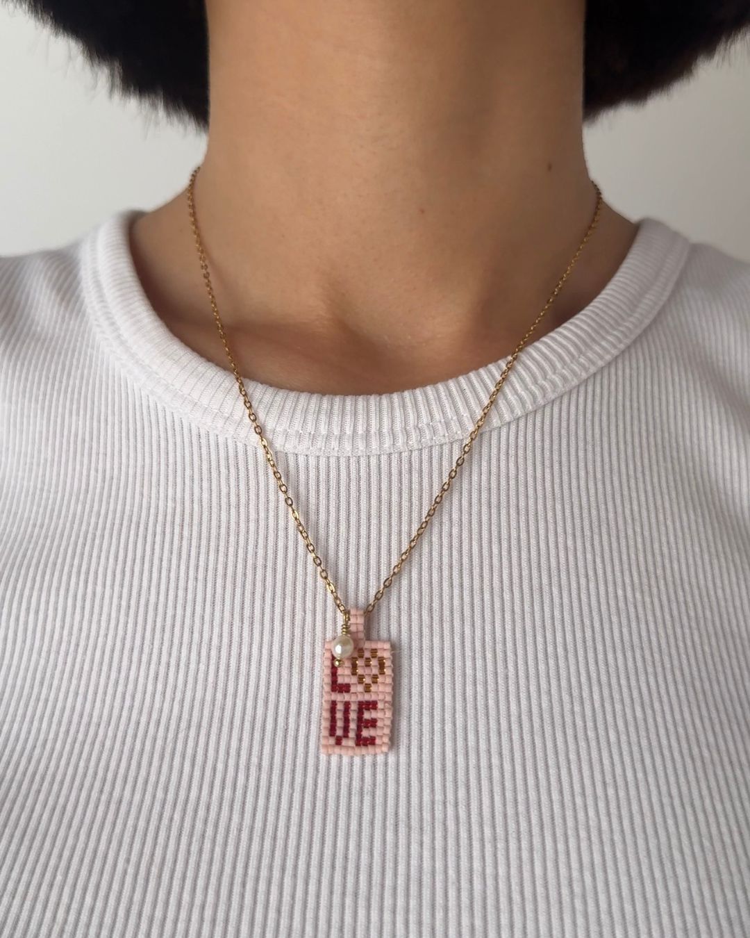 Collana a maglie sottili con pendente con scritta "love" e perla di fiume