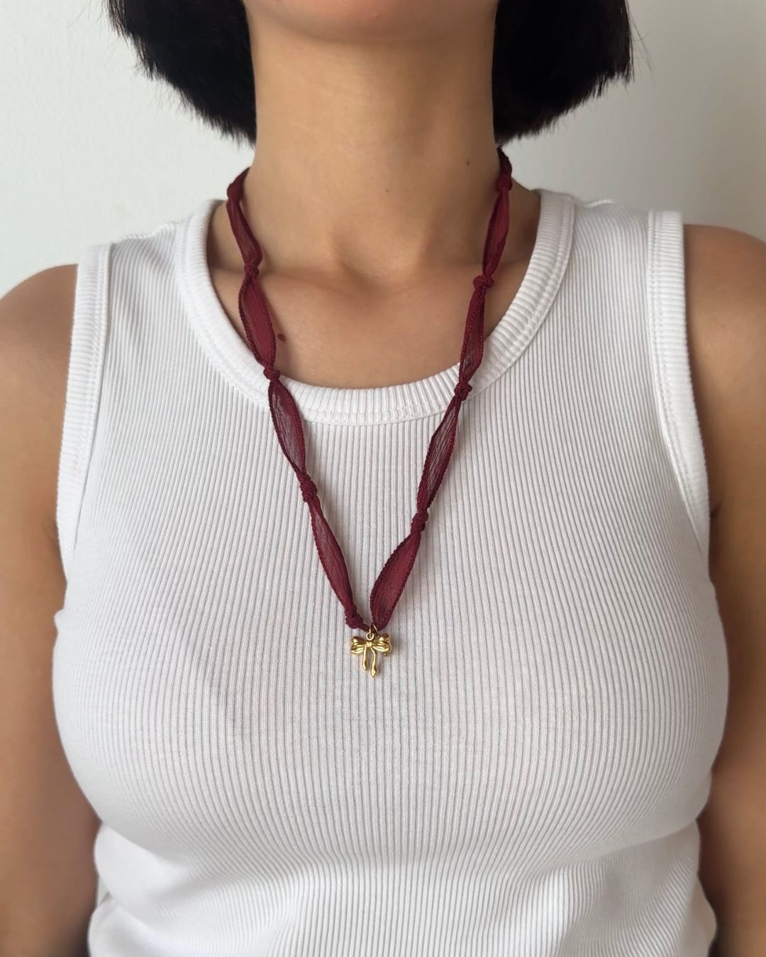 Collana in seta annodata bordeaux con pendente a forma di fiocco e pietra di tormalina