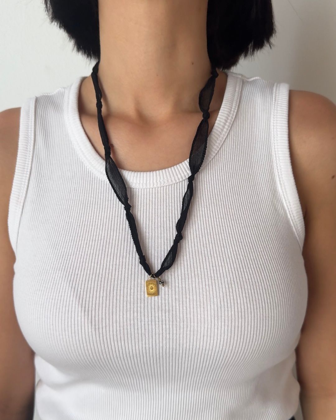 Collana in seta annodata nera con pendente a forma di sole e pietra di diaspro dalmata