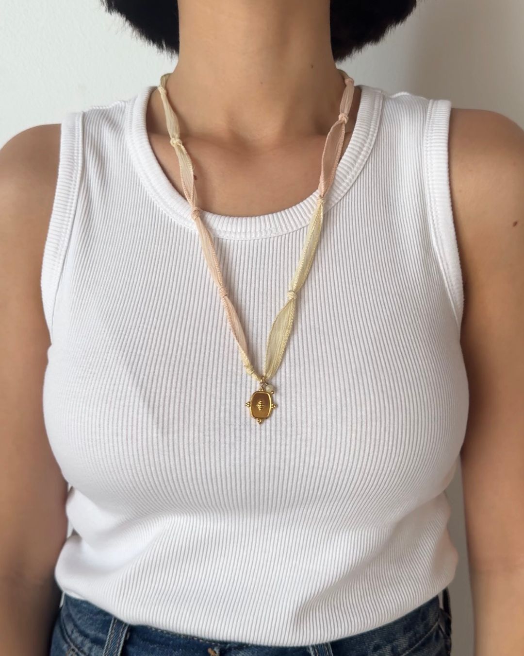 Collana in seta annodata rosa e vaniglia con pendente a forma di medaglietta e pietra di amazzonite